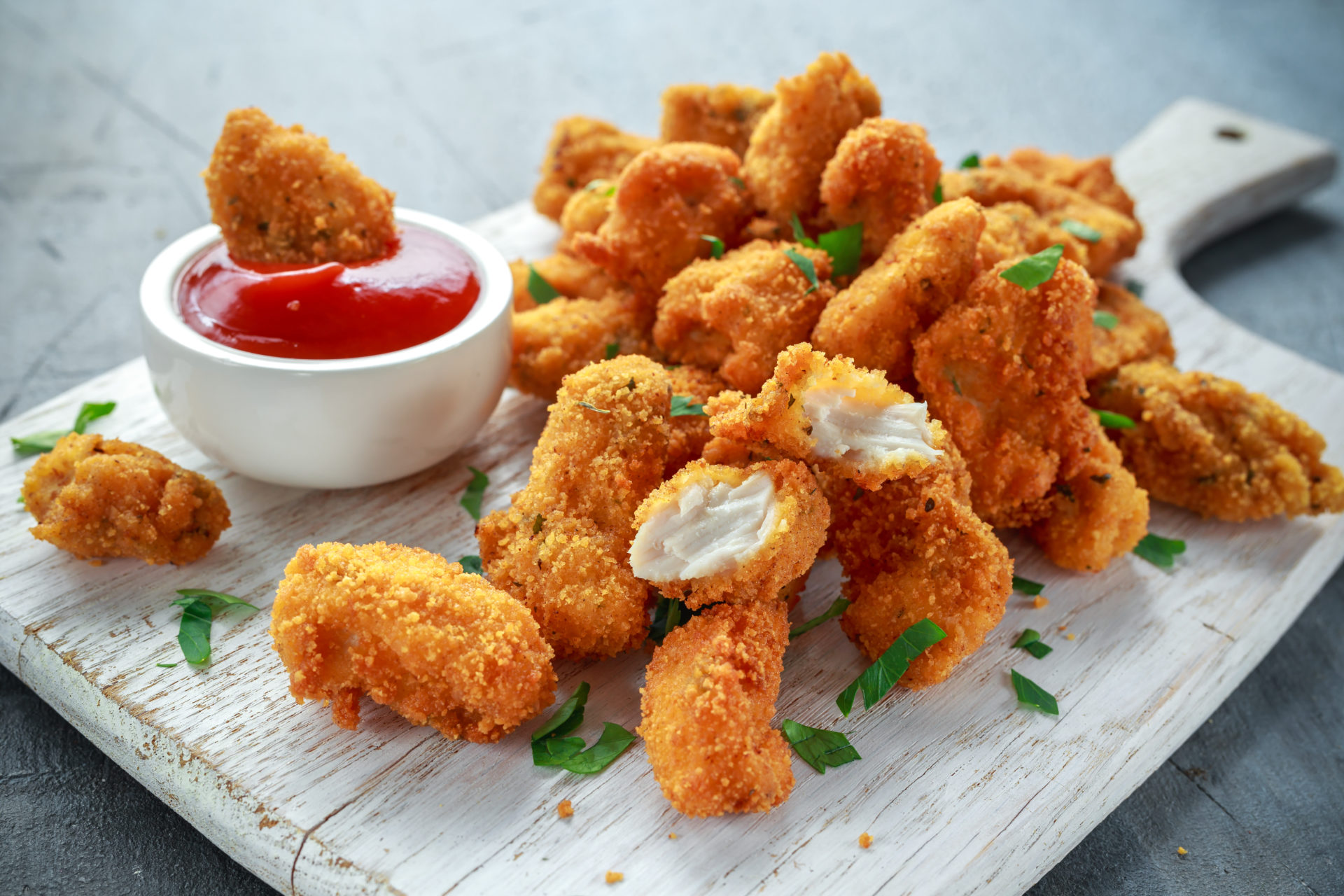 Fried crispy chicken nuggets with ketchup on white board - Tu con i ...